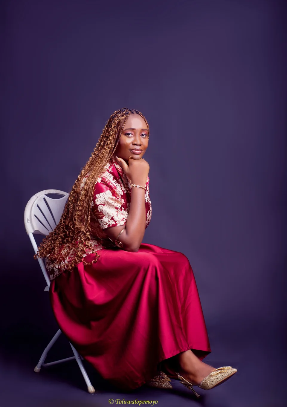 Grace seated in an editorial portrait against a purple background